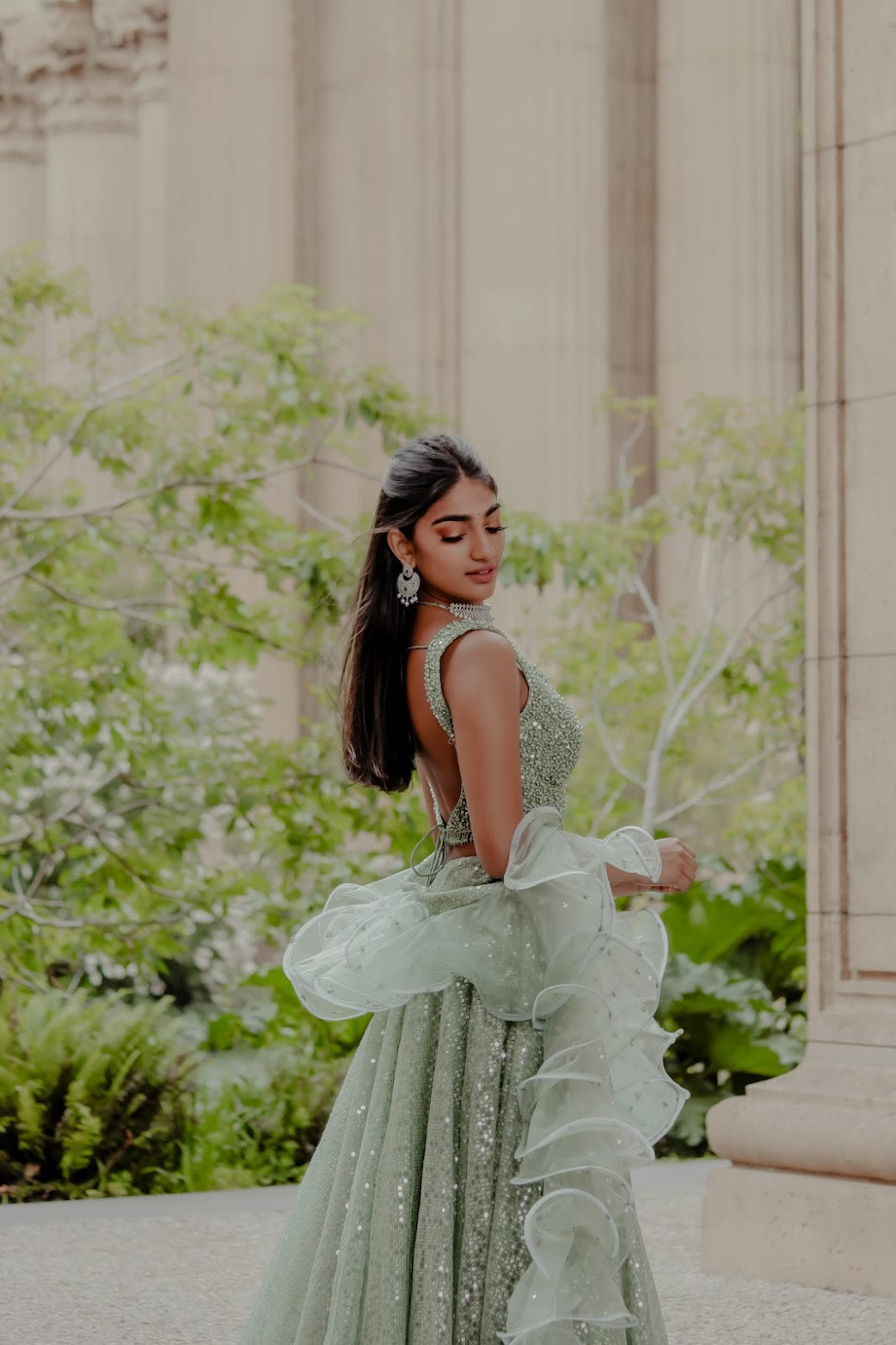 Mahika Valluri looking back in a mint sequin lehenga