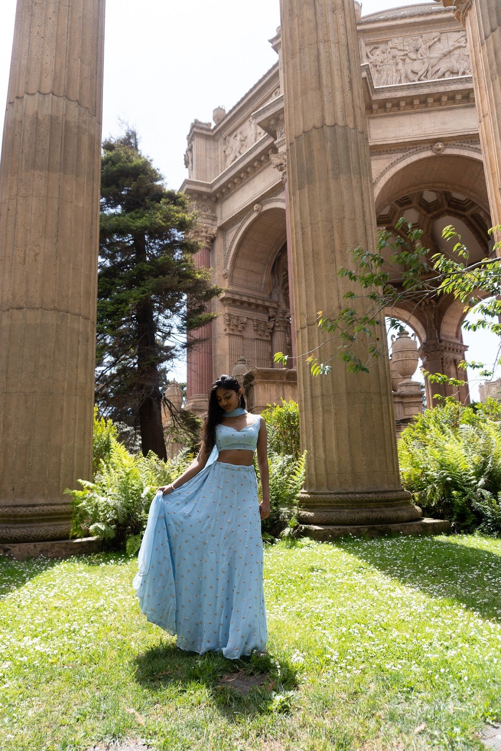 Mahika Valluri in a light blue lehenga by the Palace of Fine Arts lagoon